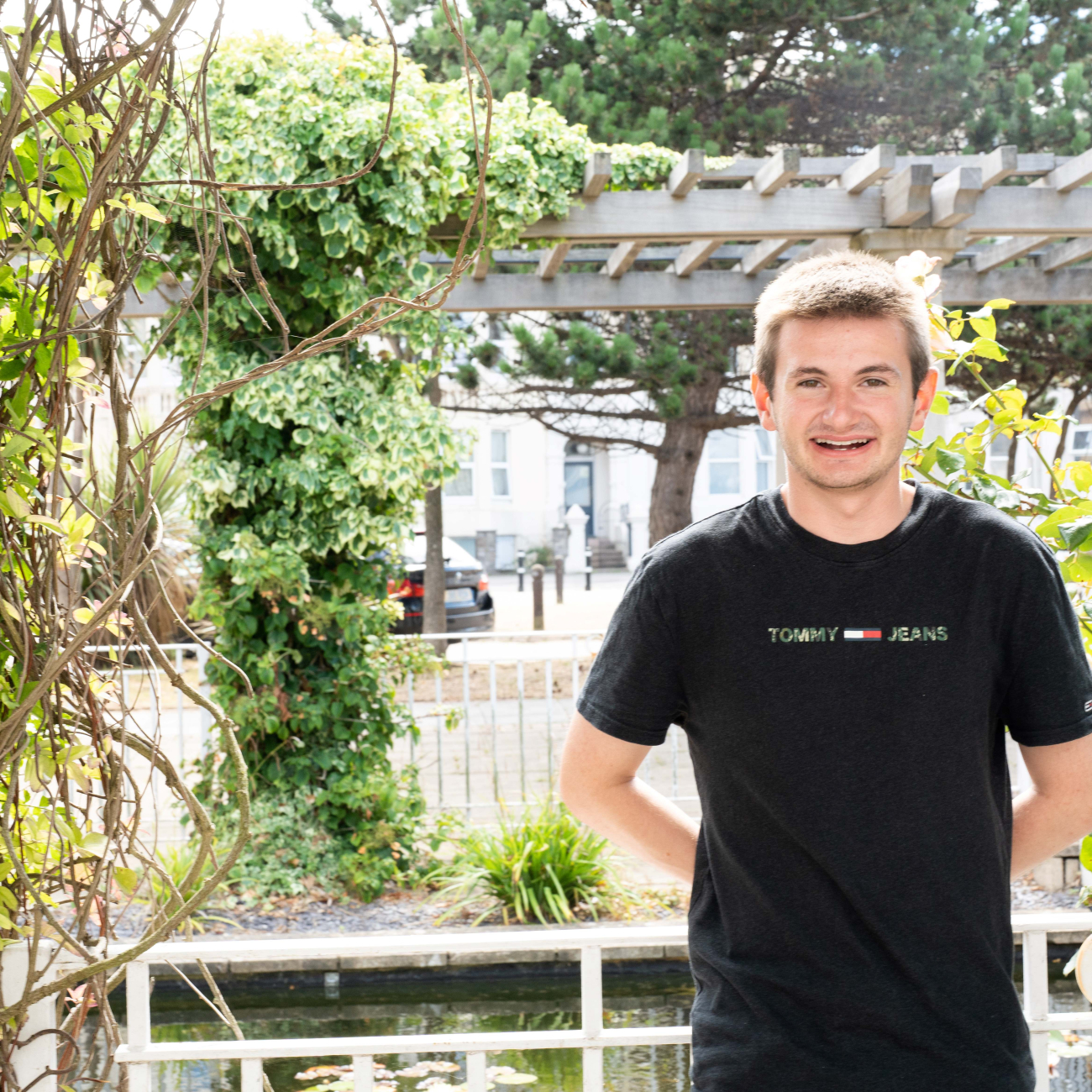 Brandon, a T Level leaner, smiling by some trees