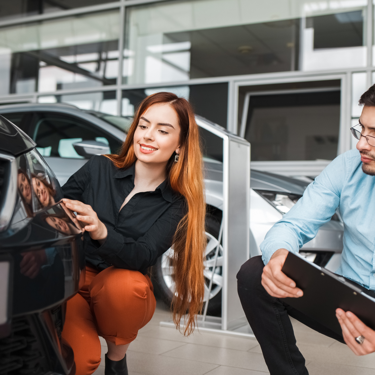 Two people looking at car