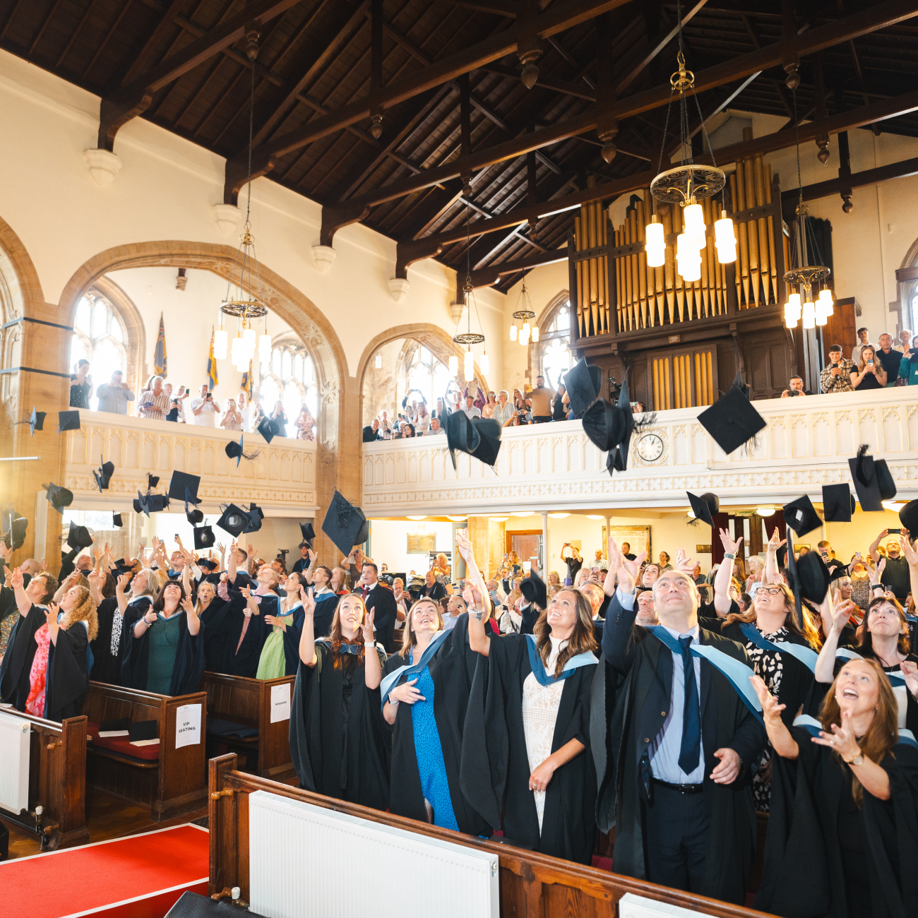 Graduating learners throwing their hats in the air
