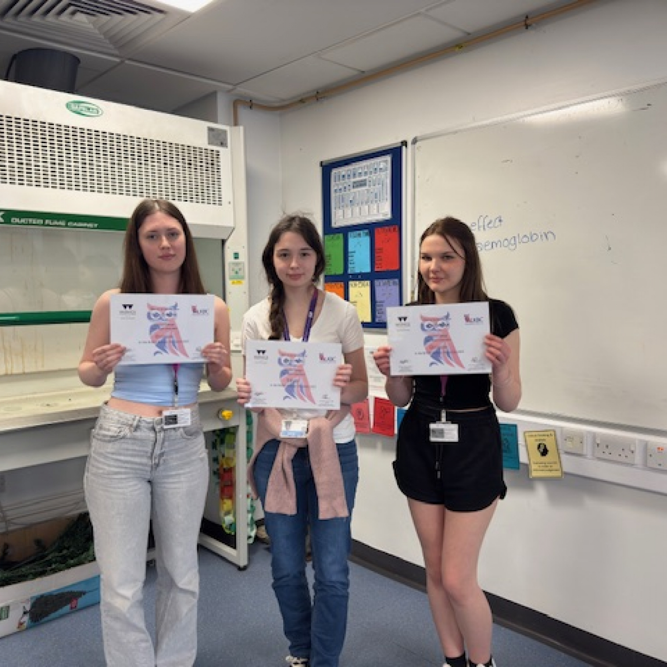 Three students holding their certificates