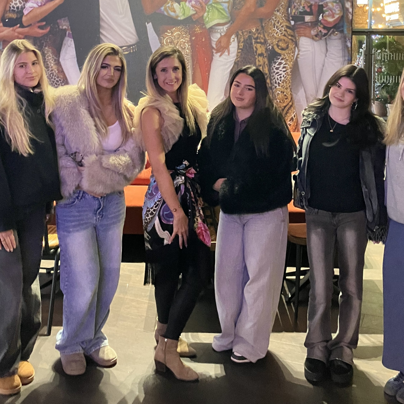 Students and lecturer standing in front of the Versace exhibition