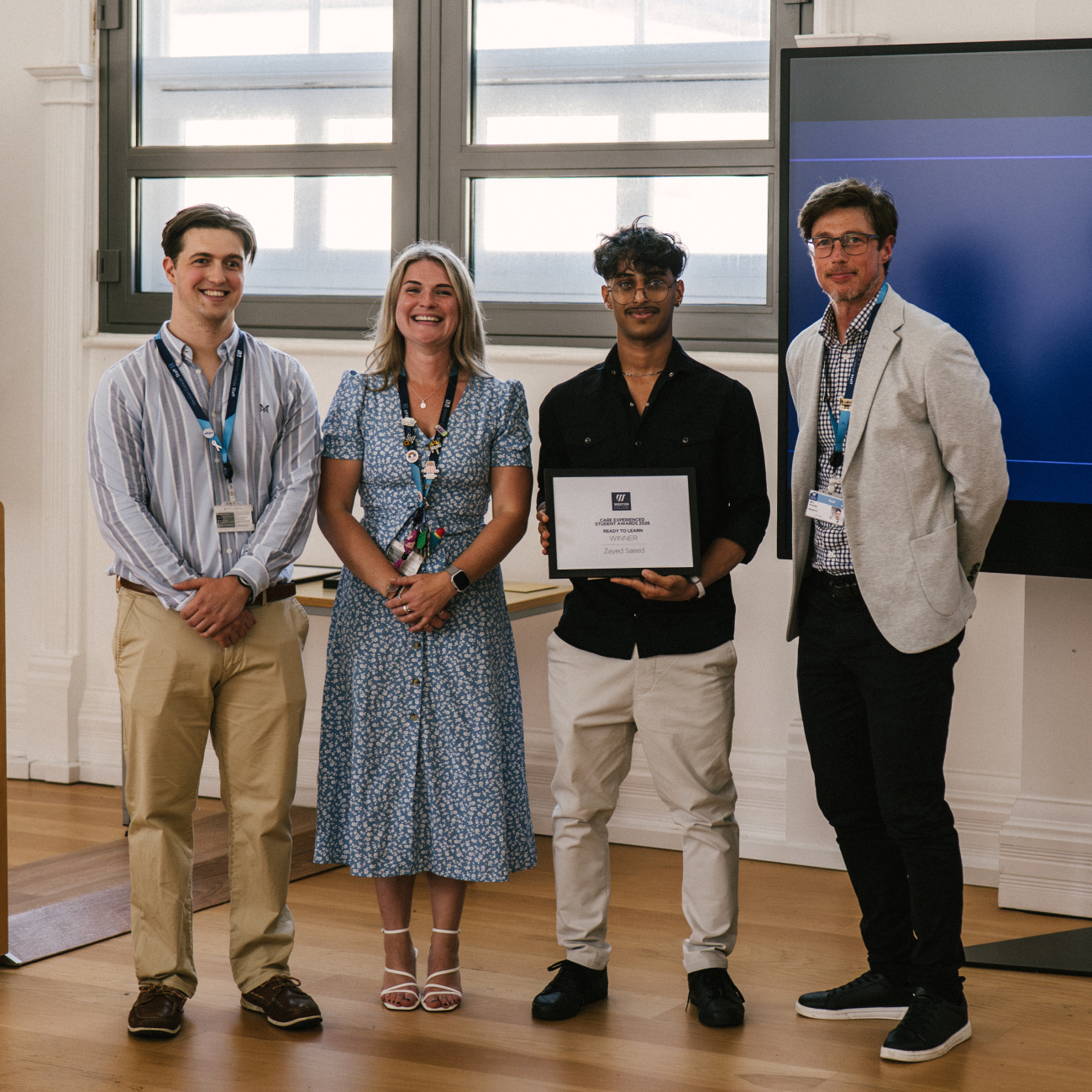 Student Holding Certificate with Staff