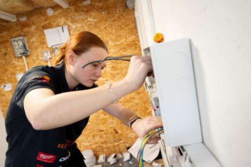 Gracie using a screwdriver to secure her electrical installation at the competition