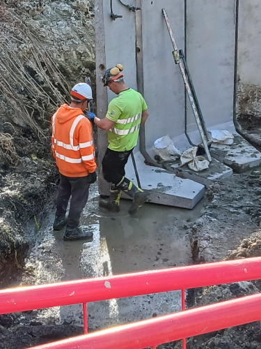 A learner being shown the levelling of concrete walls