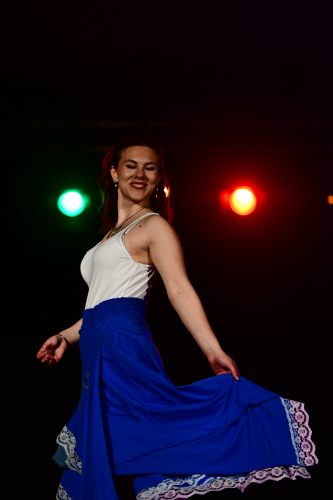 One of the models smiling and twisting her blue skirt
