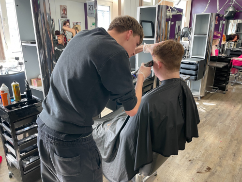 Students giving the model a skin fade