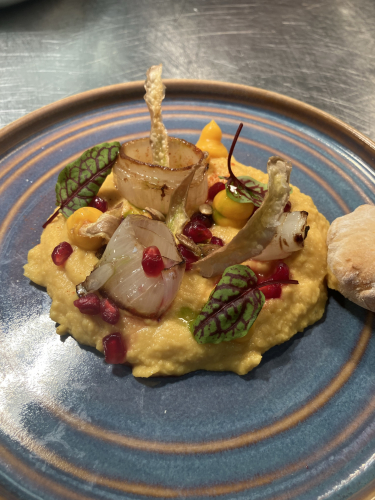 Butternut squash hummus with roasted balsamic shallots nicely presented on a plate