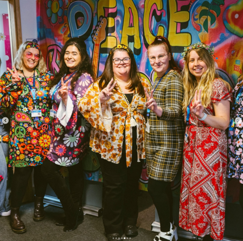 Support staff wearing flower power-themed outfits