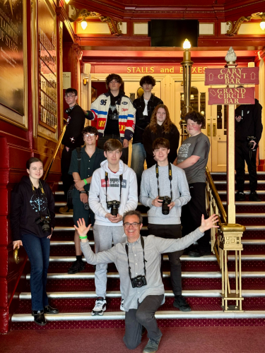 Photography students sat on the steps of the Bristol Hippodrome smiling