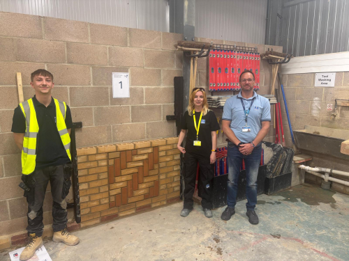 Student and lecturer standing next to his final brickwork competition submission