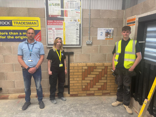 Student and lecturer standing next to his final brickwork competition submission