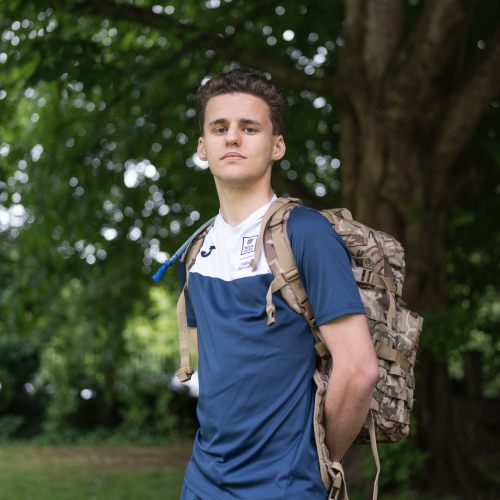 public services student stood holding map looking into camera