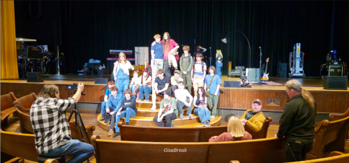 Group of students sat smiling on a stage