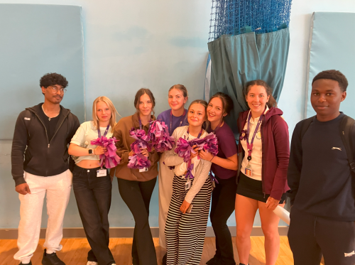 Group of Health and Social Care students wearing purple and holding pom poms