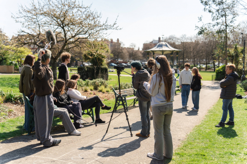 Media students filming performing arts students working on a scene
