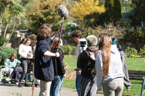 Media students filming performing arts students working on a scene