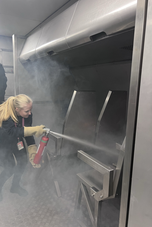 Learner using fire extinguisher in a controlled training environment