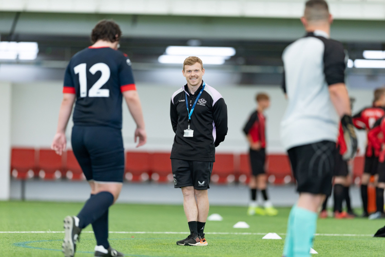 Mitch, lecturer in foundation learning and coach, standing on football pitch