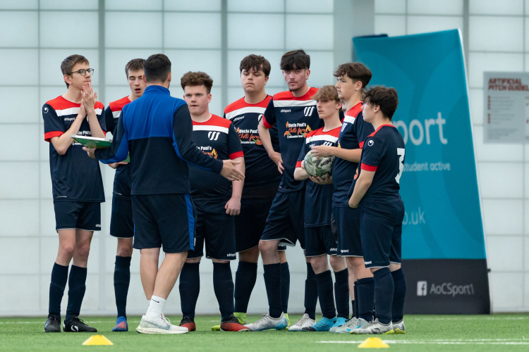 football academy students being given a pep talk on the pitch