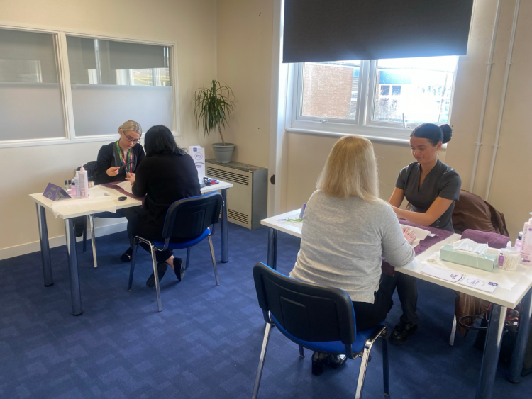Beauty students giving hand treatments to worle school staff
