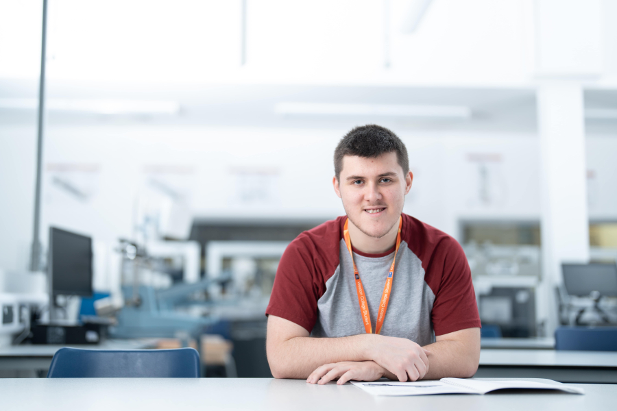 ben sitting at a desk with book in front of him