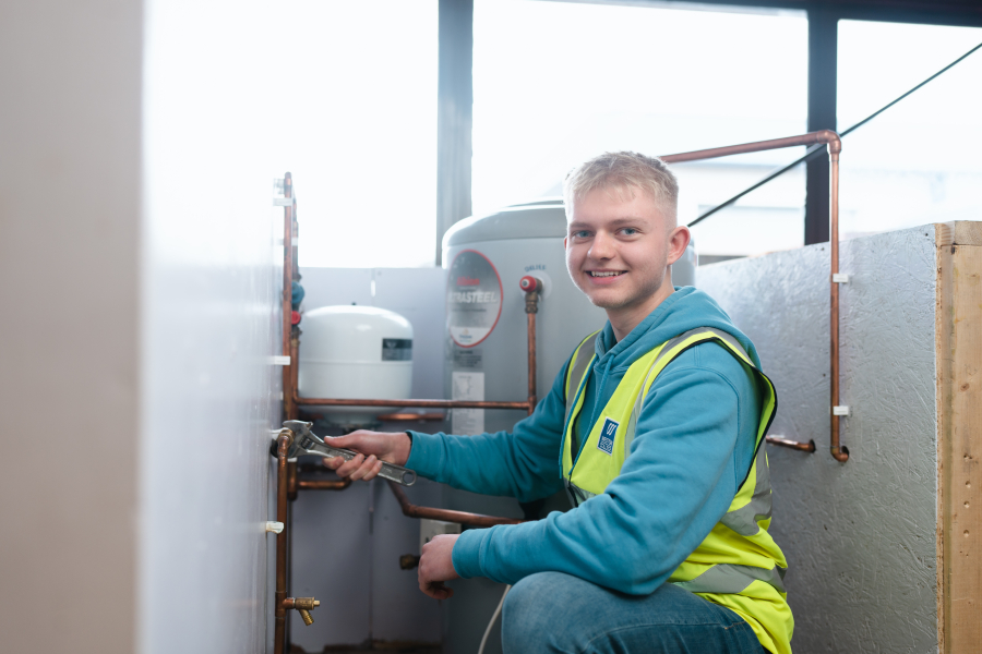 Student smiling for a photo in plumbing lesson