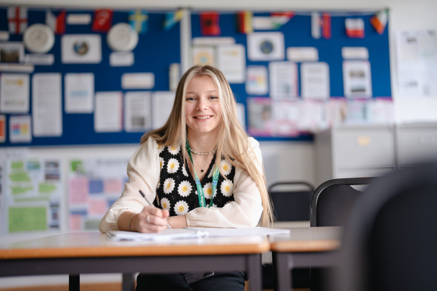 Female student sitting at desk writing